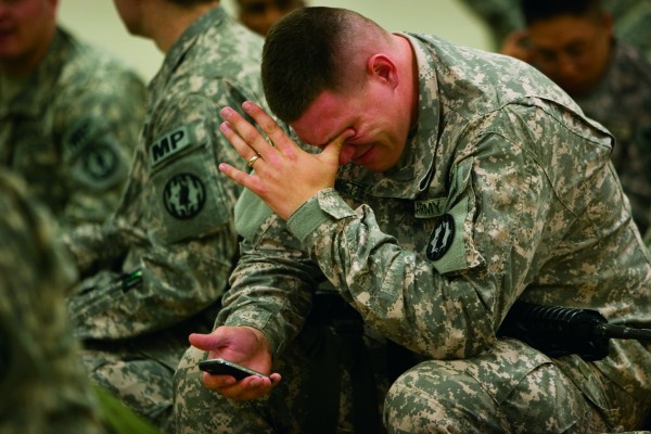 Nathan Bissonnette of the 89th MP Brigade wipes his eyes after talking to his wife on his cell phone