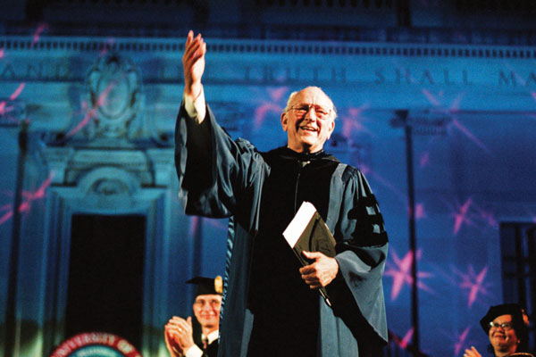 Professor Bill Livingston in front of Main Building in commencement gown. Photo by Marsha Miller