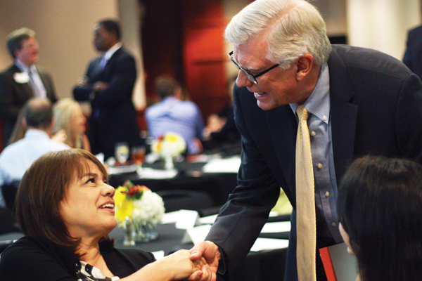 Dean Randy Diehl shaking hands with student